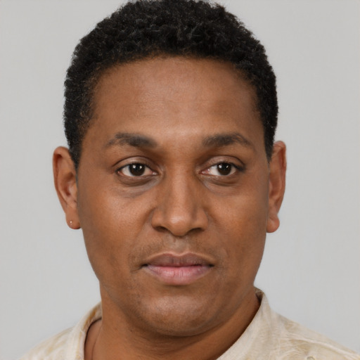 Joyful black adult male with short  brown hair and brown eyes