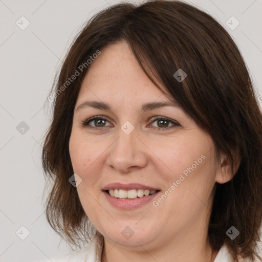 Joyful white adult female with medium  brown hair and brown eyes