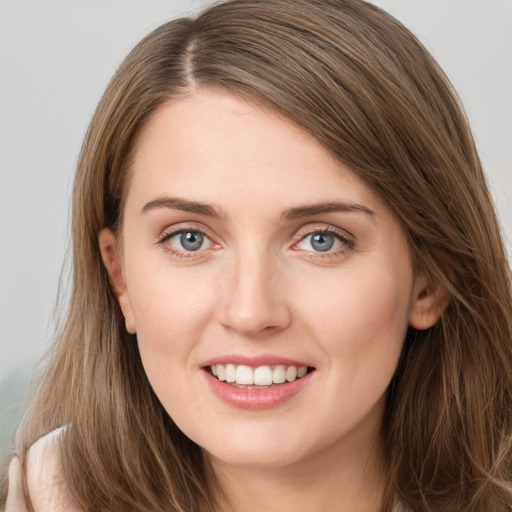 Joyful white young-adult female with long  brown hair and grey eyes