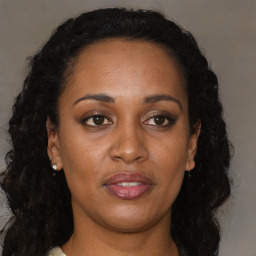 Joyful black adult female with long  brown hair and brown eyes