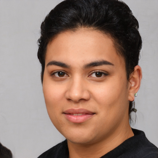Joyful latino young-adult female with short  black hair and brown eyes
