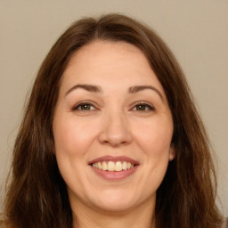 Joyful white adult female with long  brown hair and brown eyes