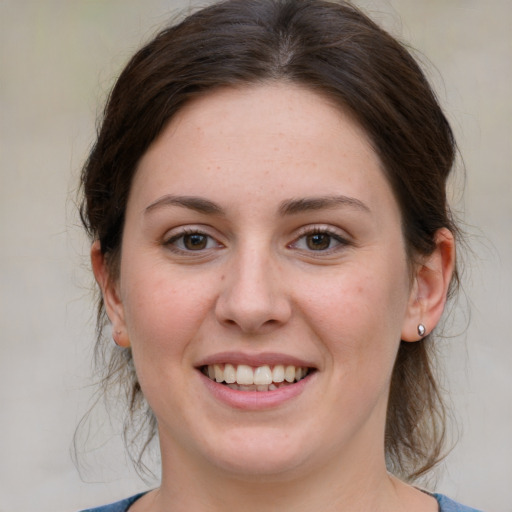 Joyful white young-adult female with medium  brown hair and grey eyes