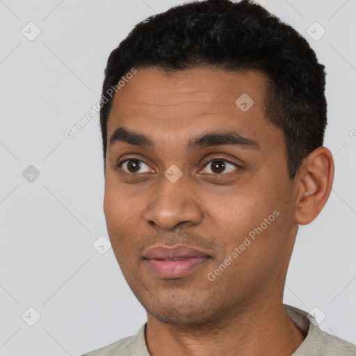 Joyful black young-adult male with short  black hair and brown eyes