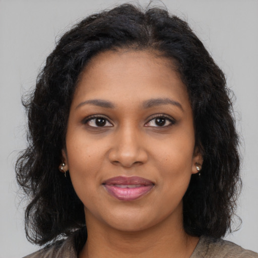 Joyful black young-adult female with long  brown hair and brown eyes