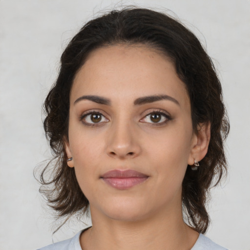 Joyful latino young-adult female with medium  brown hair and brown eyes