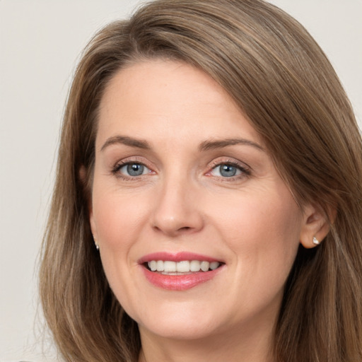 Joyful white young-adult female with long  brown hair and grey eyes