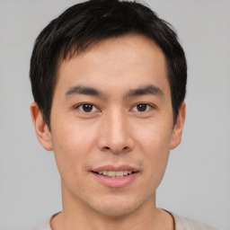 Joyful asian young-adult male with short  brown hair and brown eyes