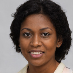 Joyful black young-adult female with long  brown hair and brown eyes