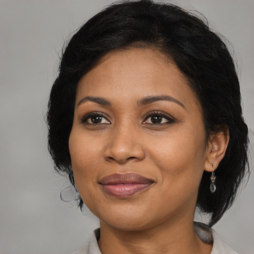 Joyful latino adult female with medium  black hair and brown eyes