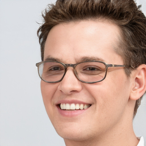 Joyful white young-adult male with short  brown hair and blue eyes