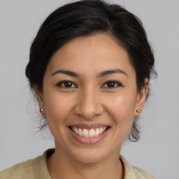 Joyful latino young-adult female with medium  brown hair and brown eyes