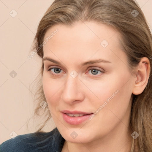 Joyful white young-adult female with long  brown hair and blue eyes