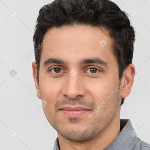 Joyful white young-adult male with short  black hair and brown eyes