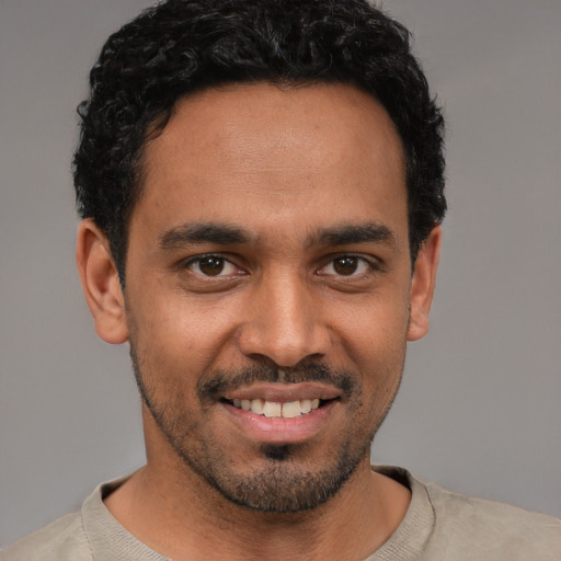 Joyful white young-adult male with short  black hair and brown eyes