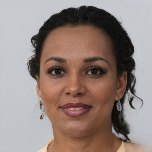 Joyful black adult female with medium  brown hair and brown eyes