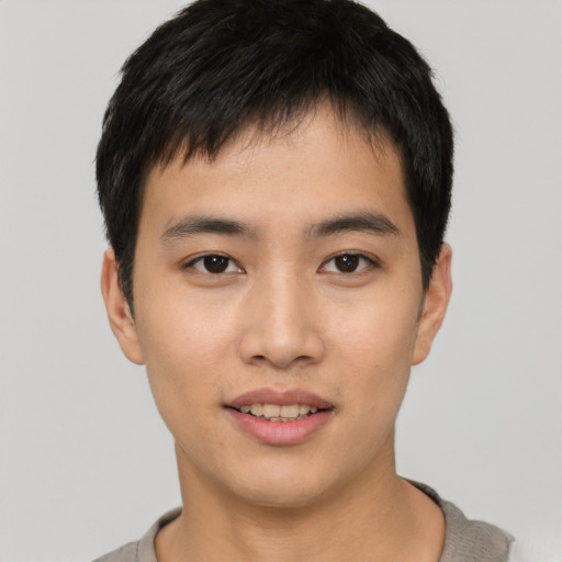 Joyful asian young-adult male with short  black hair and brown eyes