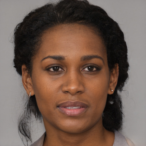 Joyful black young-adult female with medium  black hair and brown eyes