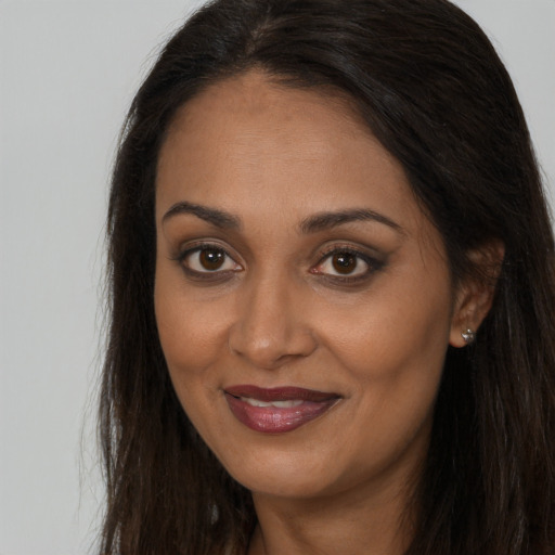 Joyful black young-adult female with long  brown hair and brown eyes