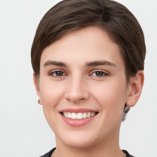 Joyful white young-adult female with short  brown hair and grey eyes