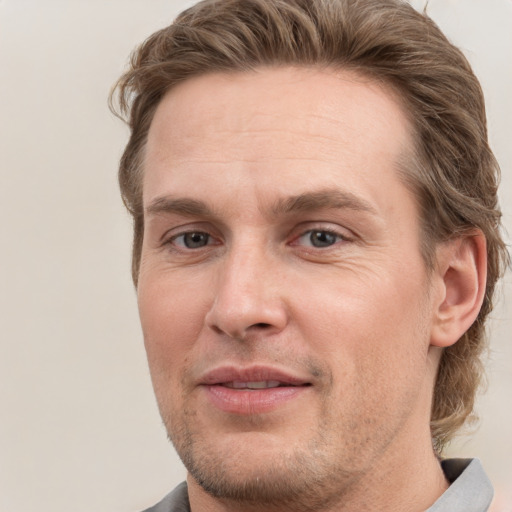 Joyful white adult male with short  brown hair and grey eyes