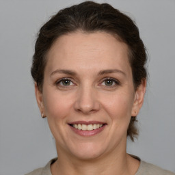 Joyful white adult female with medium  brown hair and grey eyes