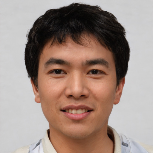 Joyful asian young-adult male with short  black hair and brown eyes