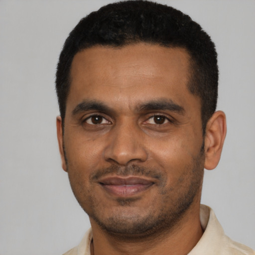 Joyful black young-adult male with short  black hair and brown eyes