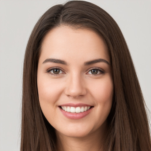 Joyful white young-adult female with long  brown hair and brown eyes