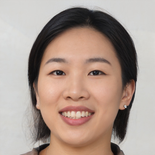 Joyful asian young-adult female with medium  black hair and brown eyes