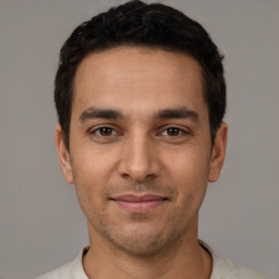 Joyful white young-adult male with short  black hair and brown eyes