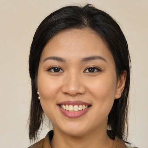Joyful latino young-adult female with medium  brown hair and brown eyes