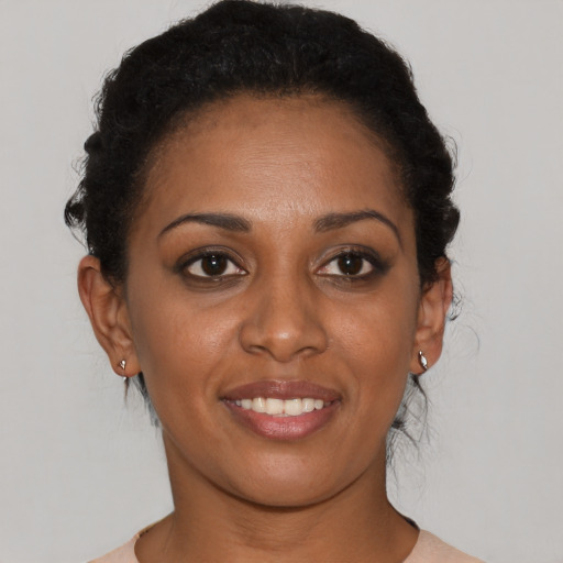 Joyful black young-adult female with short  brown hair and brown eyes