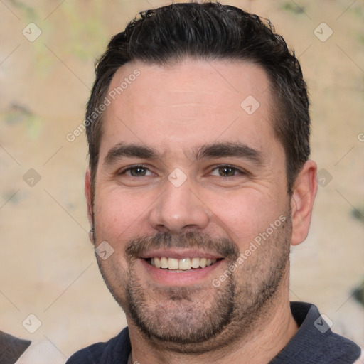 Joyful white adult male with short  black hair and brown eyes