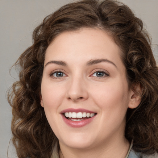 Joyful white young-adult female with medium  brown hair and green eyes