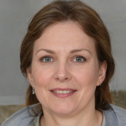 Joyful white adult female with medium  brown hair and blue eyes