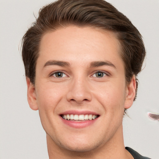 Joyful white young-adult male with short  brown hair and grey eyes