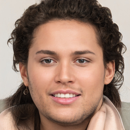 Joyful white young-adult male with long  brown hair and brown eyes