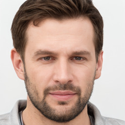 Joyful white young-adult male with short  brown hair and grey eyes