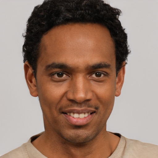 Joyful black young-adult male with short  black hair and brown eyes