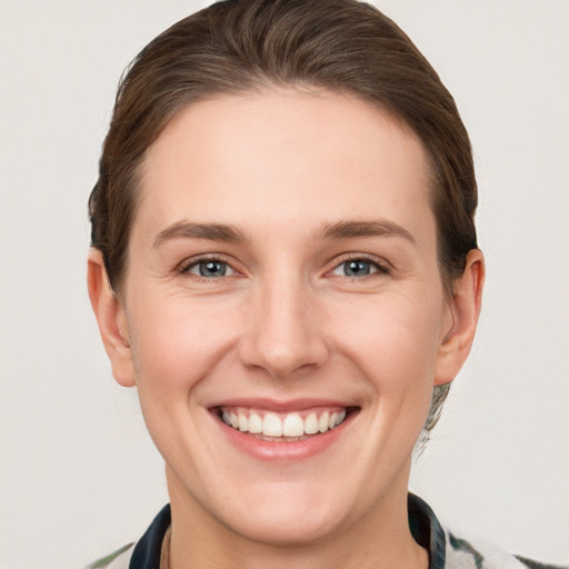 Joyful white young-adult female with short  brown hair and grey eyes