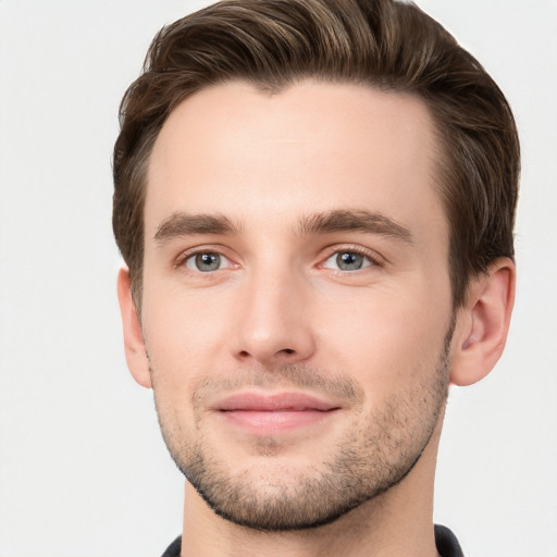 Joyful white young-adult male with short  brown hair and grey eyes