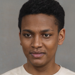 Joyful black young-adult male with short  black hair and brown eyes