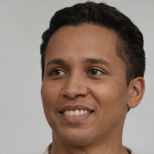 Joyful black adult male with short  black hair and brown eyes