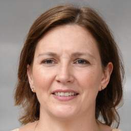 Joyful white adult female with medium  brown hair and grey eyes