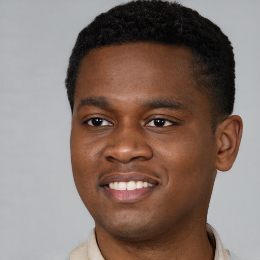 Joyful black young-adult male with short  brown hair and brown eyes