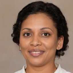 Joyful black adult female with medium  brown hair and brown eyes