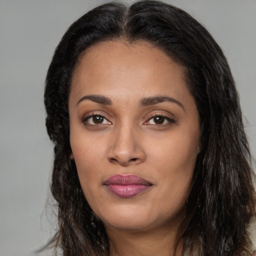 Joyful black young-adult female with long  brown hair and brown eyes