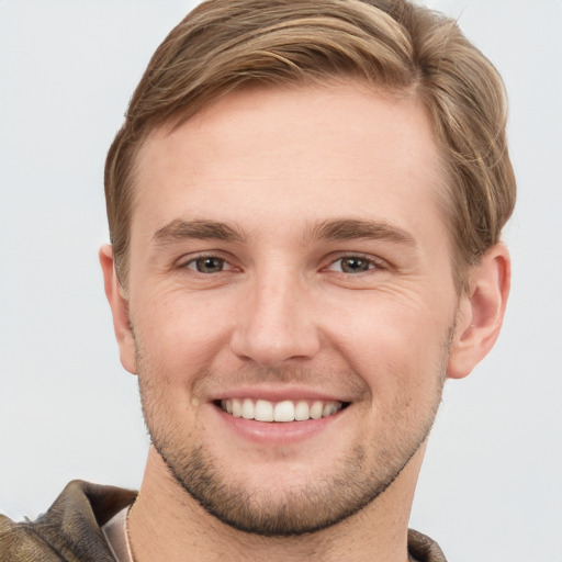 Joyful white young-adult male with short  brown hair and grey eyes