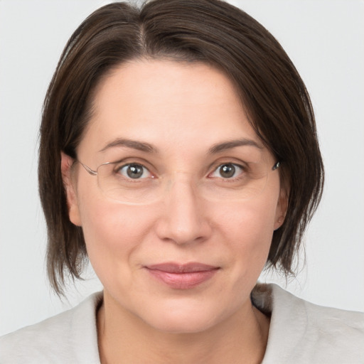 Joyful white adult female with medium  brown hair and grey eyes